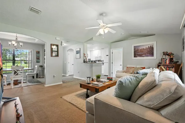 a living room with furniture and view of kitchen