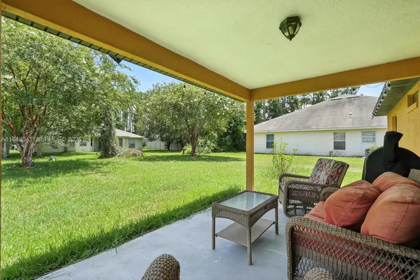 a view of a porch with furniture and a yard