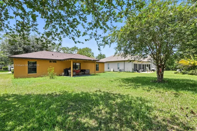 a view of a grassy field with trees in the background
