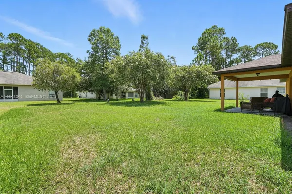 a view of a grassy field with trees in the background