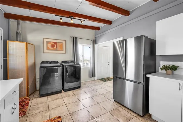 a metallic refrigerator freezer and a stove sitting inside of a kitchen