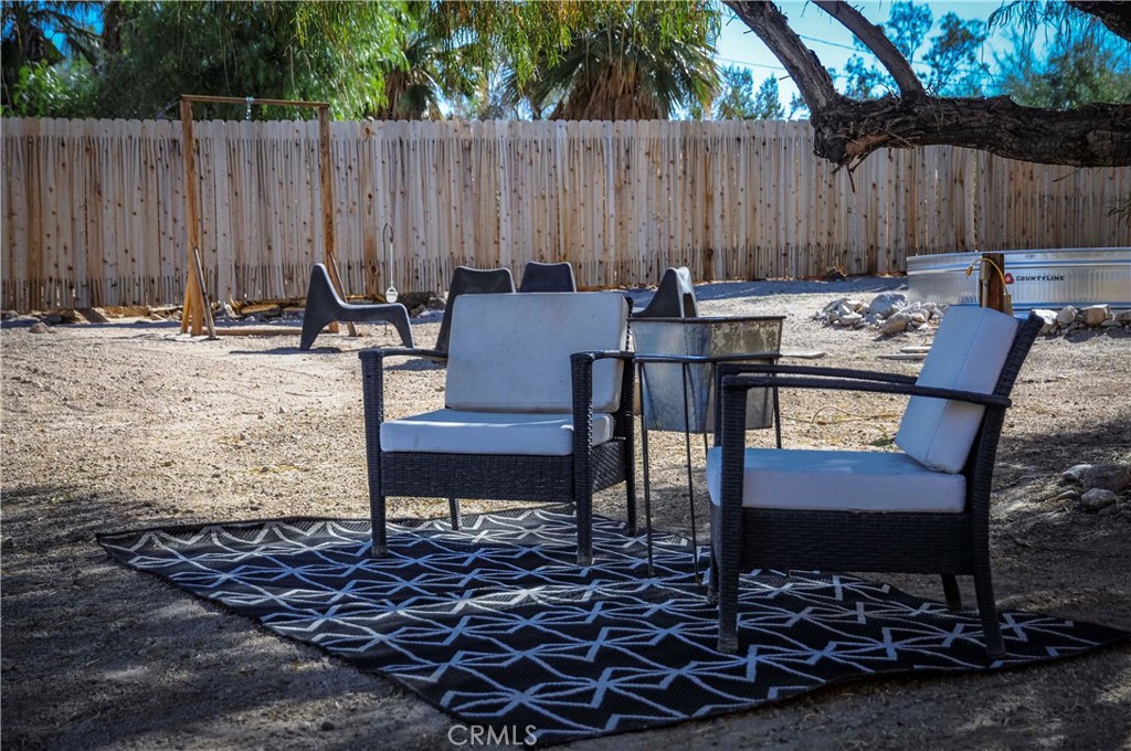 74825 Alta Loma Drive Twentynine Palms, CA 92277 - Photo 28 of 36 a backyard of a house with table and chairs