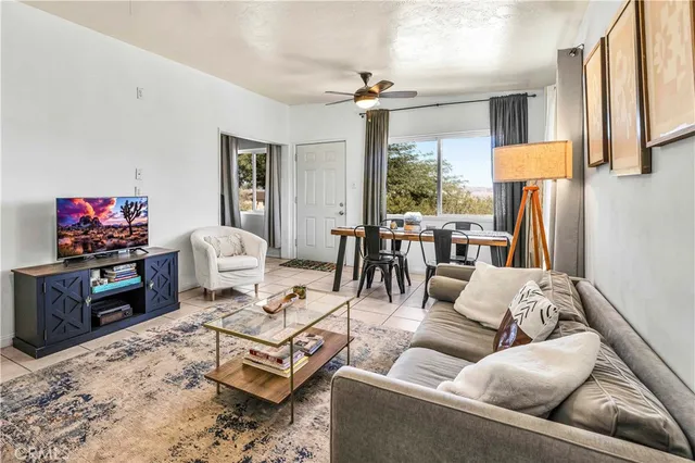 a living room with furniture a large window and a flat screen tv