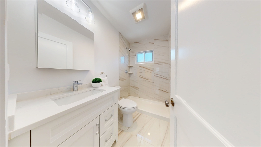 333 Vermont Street, Unit 2 Boston, MA 02132 - Photo 16 of 24 a bathroom with a sink a toilet a mirror and shower