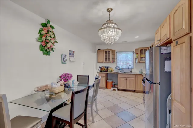a view of a dining room with furniture chandelier and kitchen view