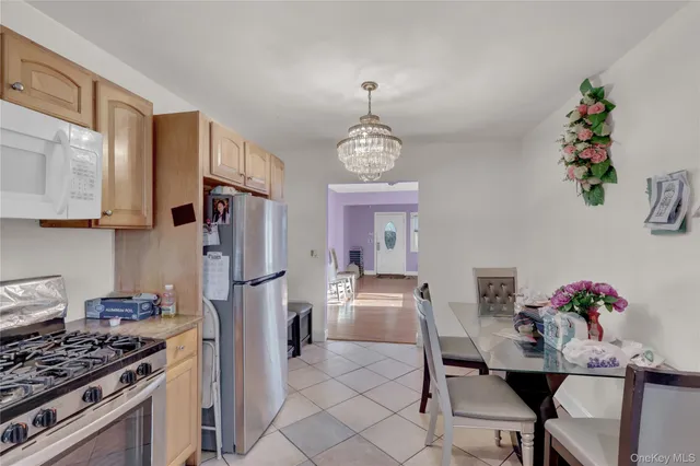 a kitchen with stainless steel appliances granite countertop a stove a refrigerator and a dining table