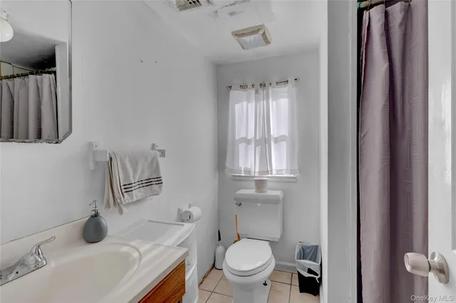 a bathroom with a toilet a sink and mirror
