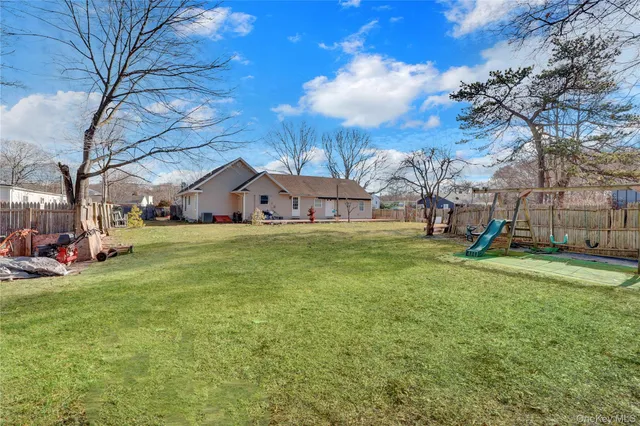 a view of a house with a big yard and large tree