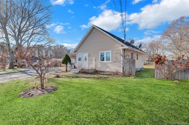 a view of a house with a yard and a tree