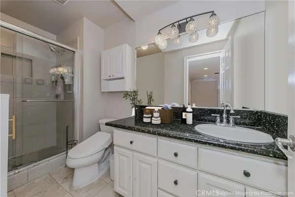 a bathroom with a granite countertop sink a toilet and shower