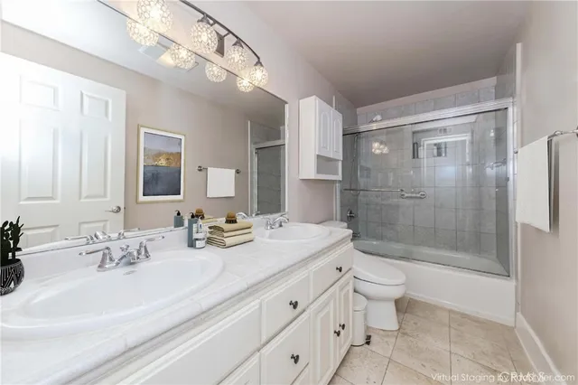 a bathroom with a double vanity sink toilet and shower