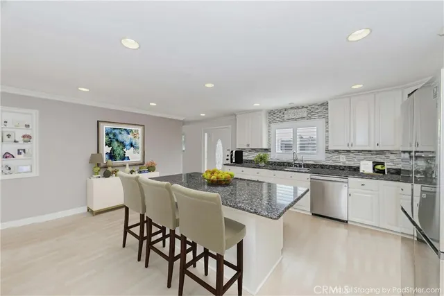 a kitchen with stainless steel appliances granite countertop a table and chairs in it