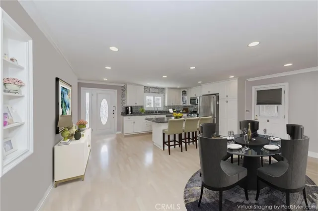 a living room with lots of furniture kitchen view and a dining table