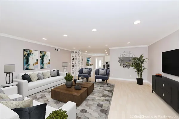 a living room with furniture a flat screen tv and a potted plant