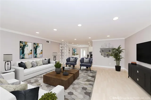 a living room with furniture a flat screen tv and a potted plant