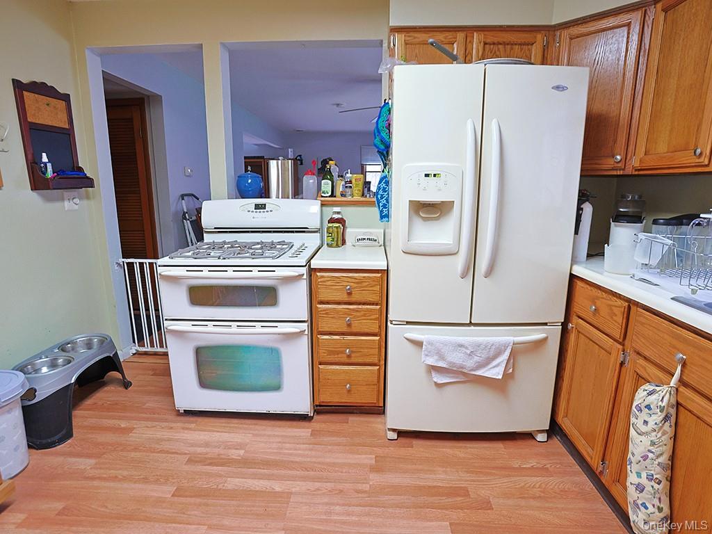 68 Kennel Road Cuddebackville, NY 12729 - Photo 13 of 21 a white refrigerator freezer and a stove sitting inside of a kitchen