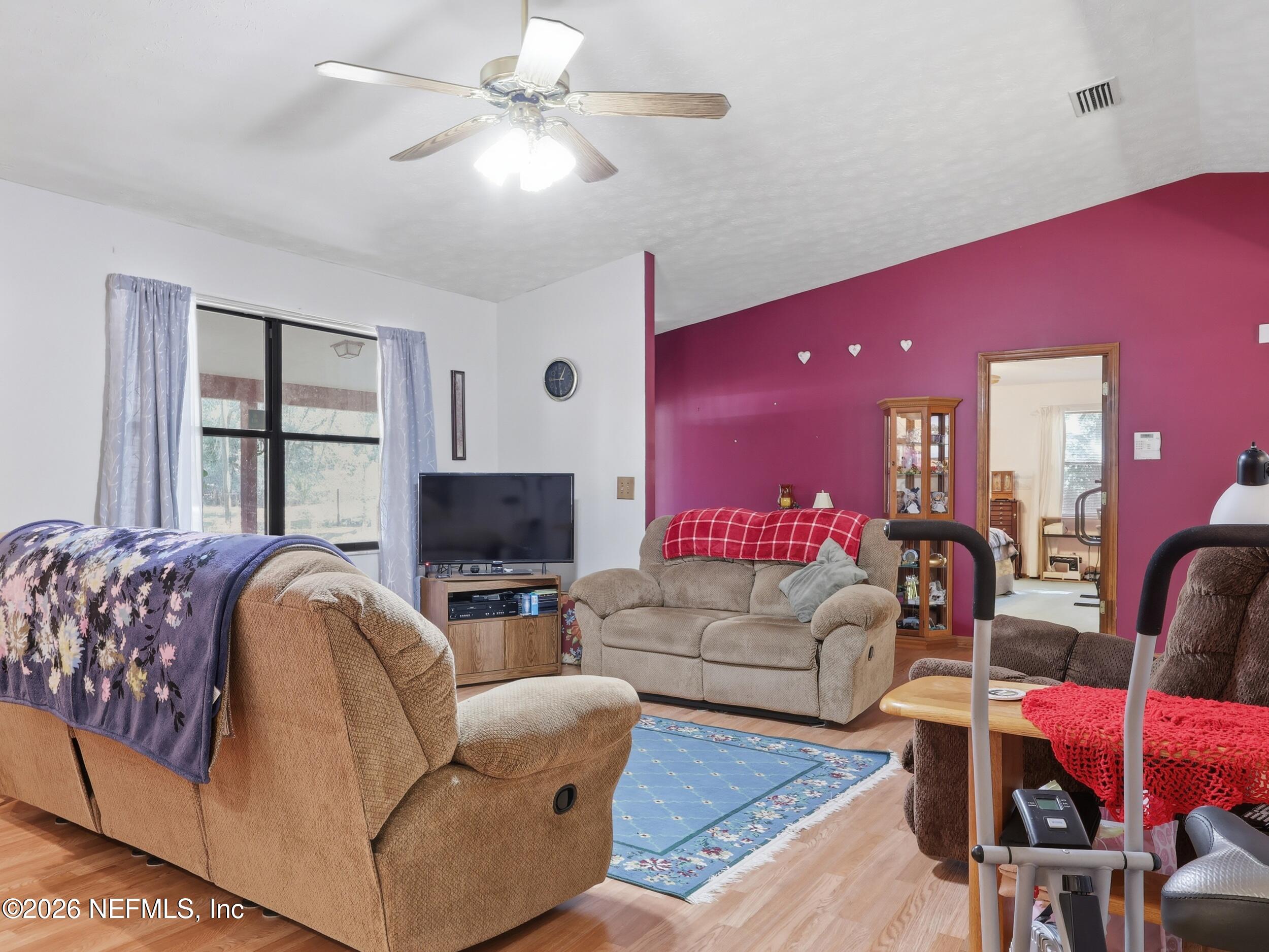 8336 Singleton Place Keystone Heights, FL 32656 - Photo 15 of 56 a living room with furniture ceiling fan and a rug