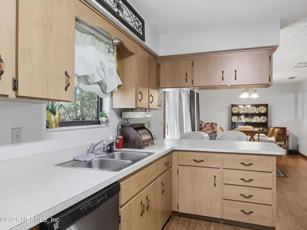 a kitchen with stainless steel appliances a sink a stove and white cabinets