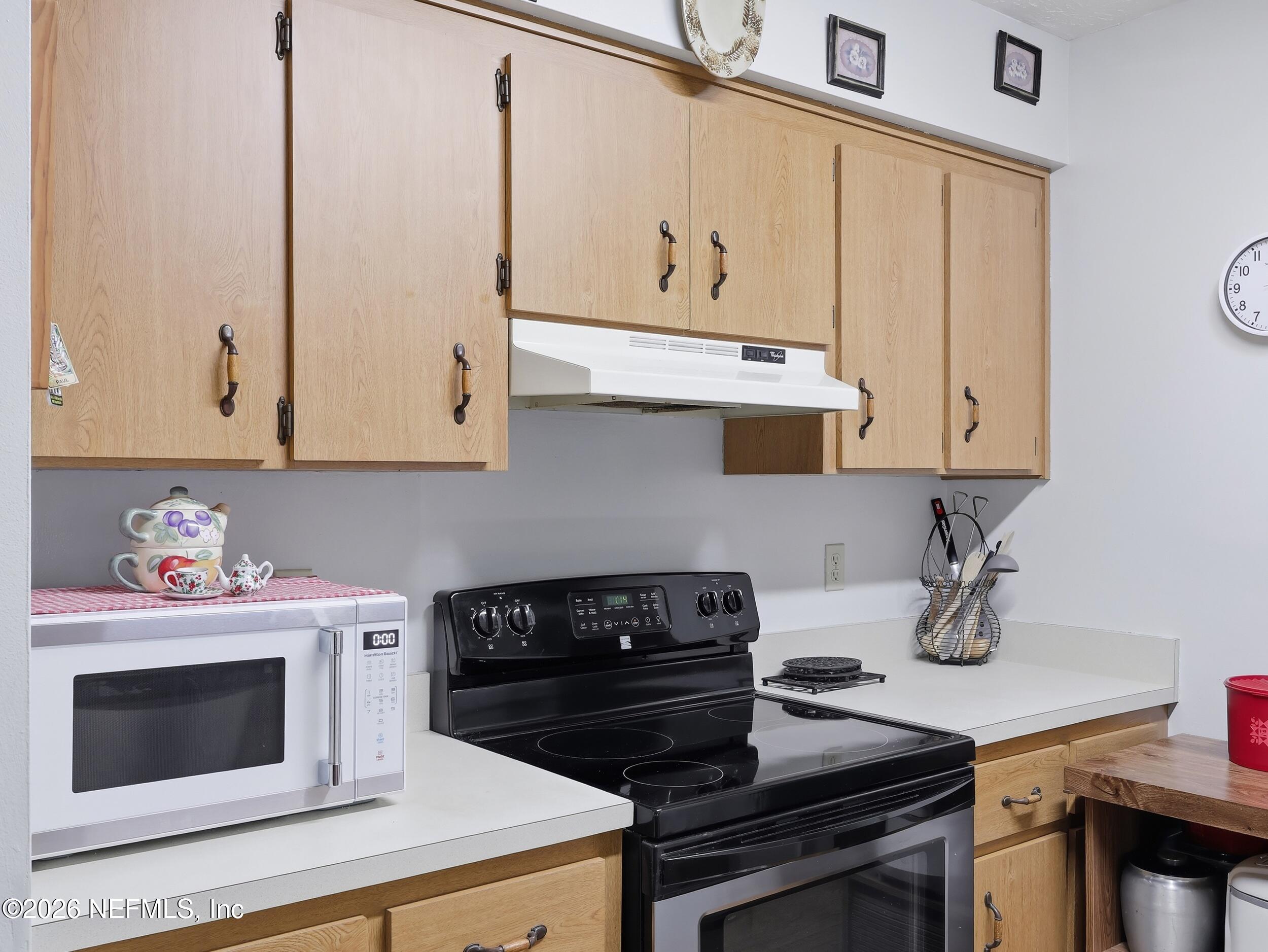 8336 Singleton Place Keystone Heights, FL 32656 - Photo 21 of 56 a kitchen with granite countertop cabinets a stove and a wooden floor
