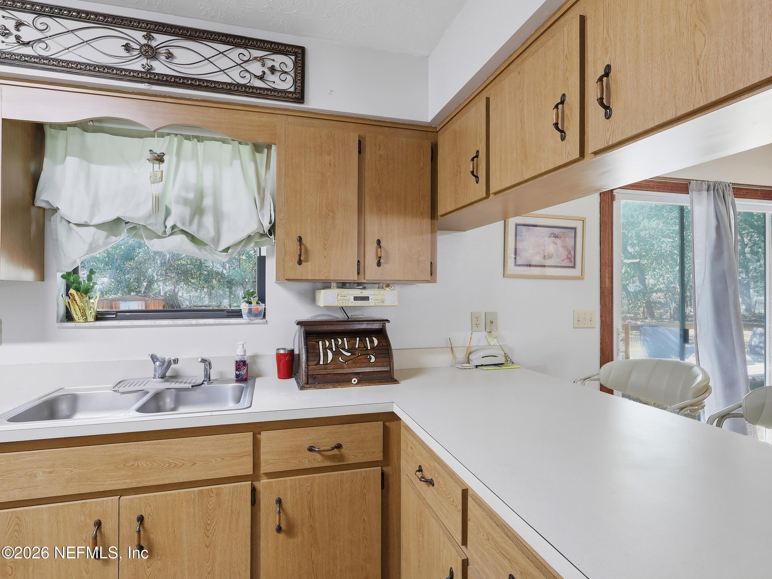 8336 Singleton Place Keystone Heights, FL 32656 - Photo 23 of 56 a kitchen with stainless steel appliances a sink a stove and white cabinets
