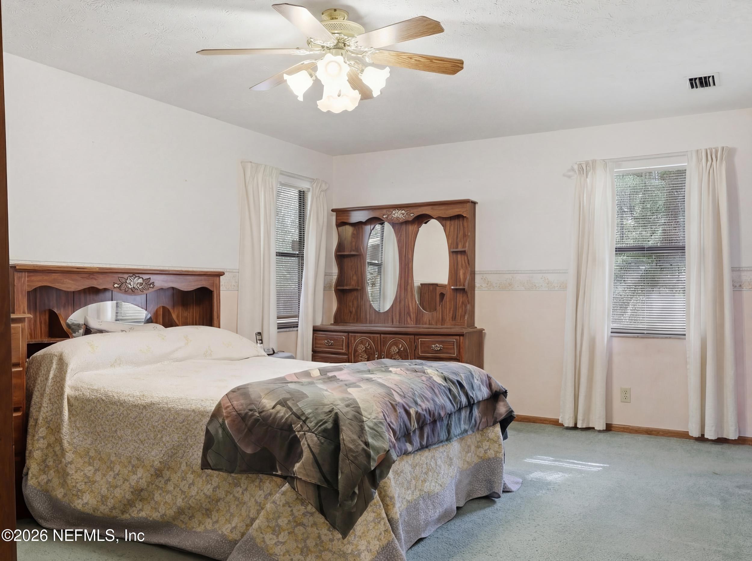 8336 Singleton Place Keystone Heights, FL 32656 - Photo 26 of 56 a bedroom with a bed and a chandelier