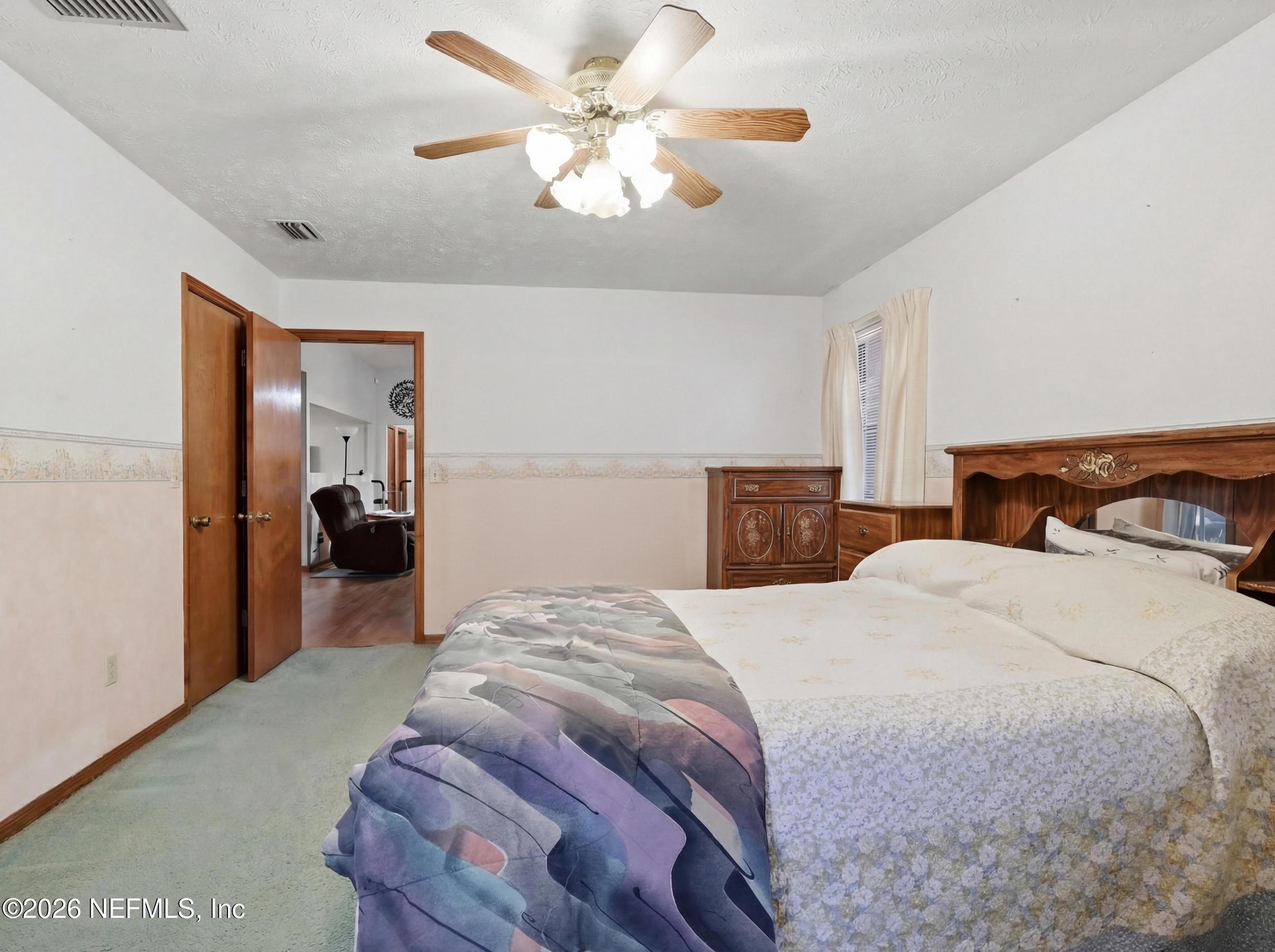 8336 Singleton Place Keystone Heights, FL 32656 - Photo 28 of 56 a bedroom with a bed and a chandelier