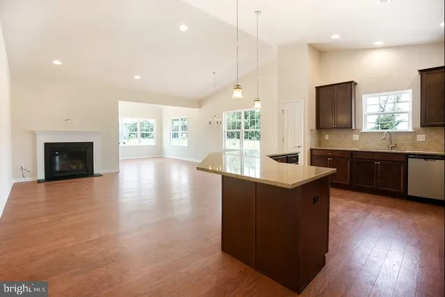 a large kitchen with stainless steel appliances granite countertop a stove and a wooden floors
