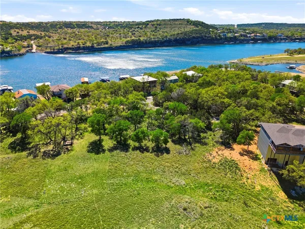 an aerial view of residential houses with outdoor space and lake view
