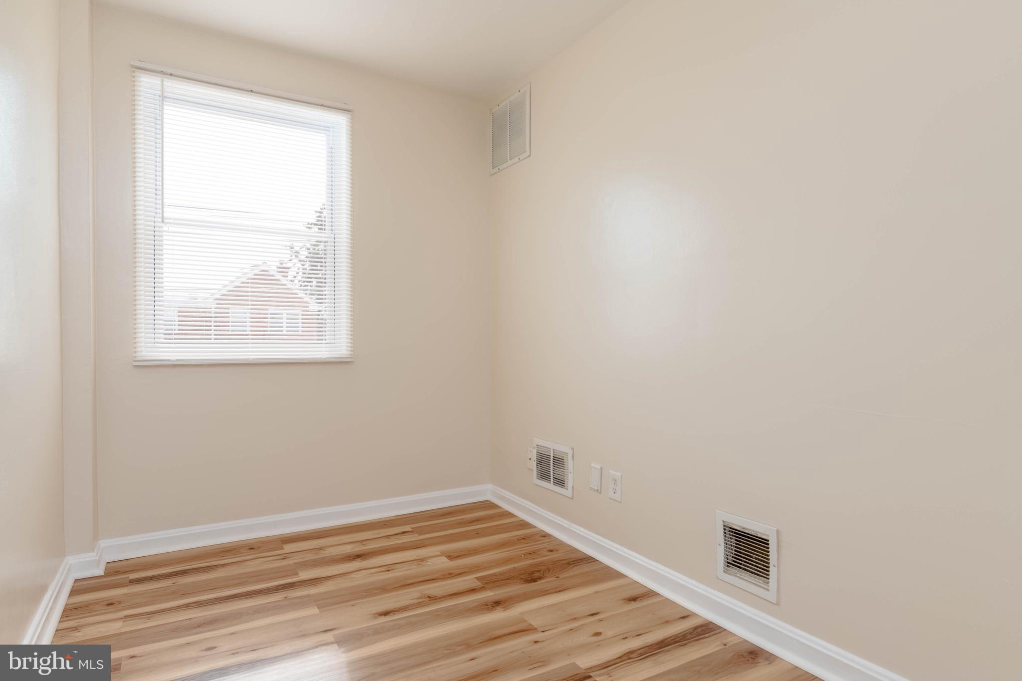 5413 Channing Road Baltimore, MD 21229 - Photo 21 of 45 an empty room with wooden floor and windows