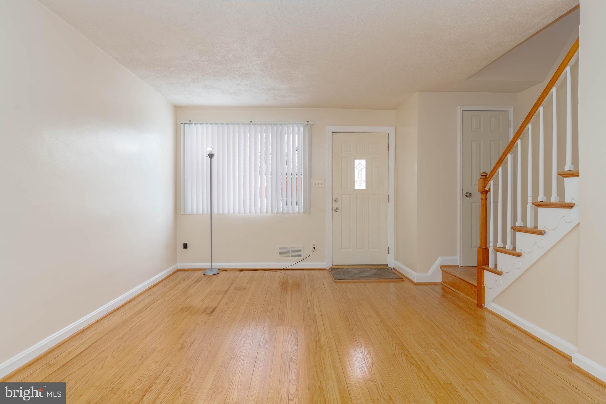 5413 Channing Road Baltimore, MD 21229 - Photo 4 of 45 a view of an empty room with wooden floor and stairs