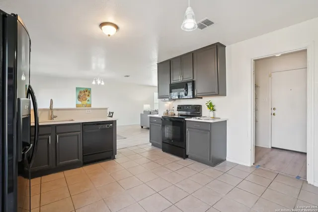 a kitchen with stainless steel appliances granite countertop a refrigerator and a stove top oven