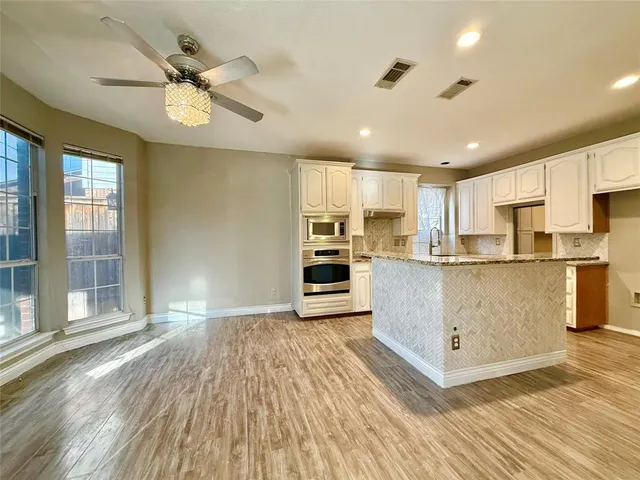 a view of kitchen with stainless steel appliances refrigerator oven and cabinets