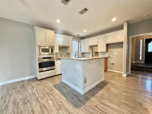 a kitchen with stainless steel appliances a refrigerator and a stove top oven