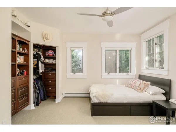 a bedroom with a bed a large window and a chandelier