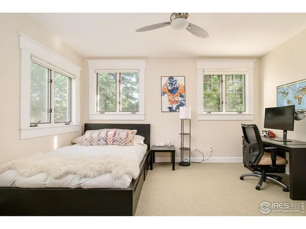 a bedroom with a bed and large windows