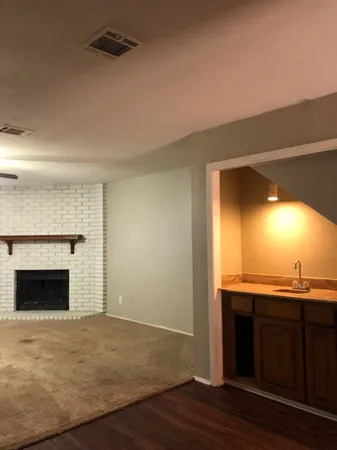 an empty room with a fireplace and wooden floor