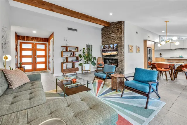 a view of a backyard with lawn chairs under an umbrella