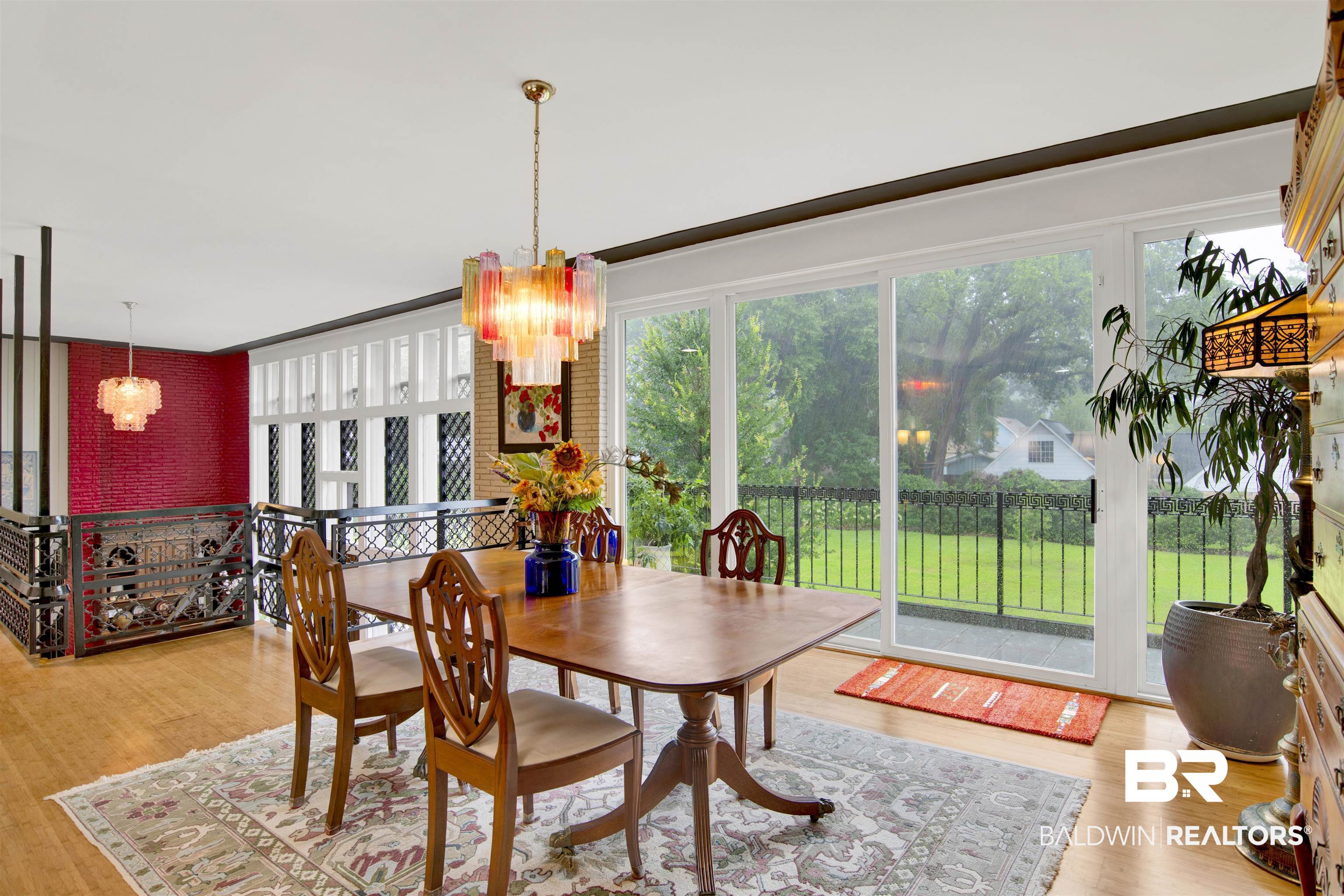 809 Bernard Circle Mobile, AL 36693 - Photo 26 of 75 Spacious dining area featuring wood-finish flooring, a large area rug, and a colorful chandelier