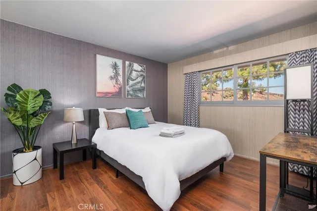 a bed sitting in a bedroom next to a window