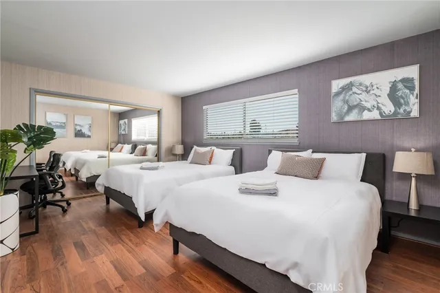 a large bedroom with a bed and wooden floor