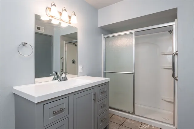 a bathroom with a sink vanity and shower