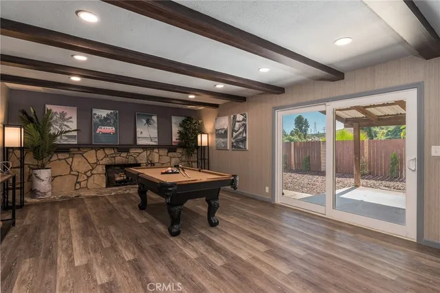a room with furniture pool table wooden floor and windows