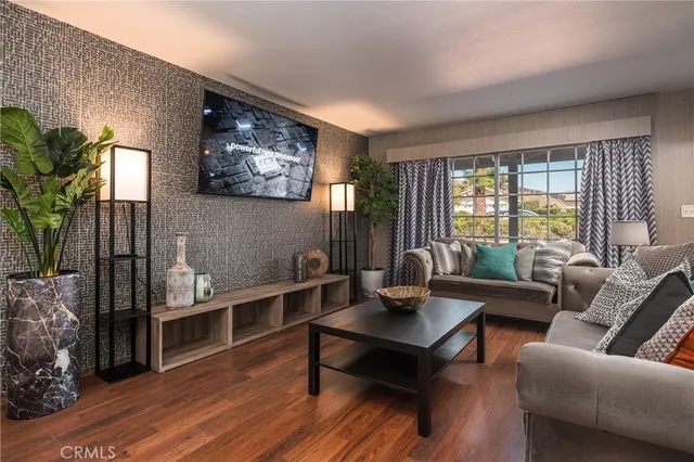 a living room with furniture a rug potted plant and a large window