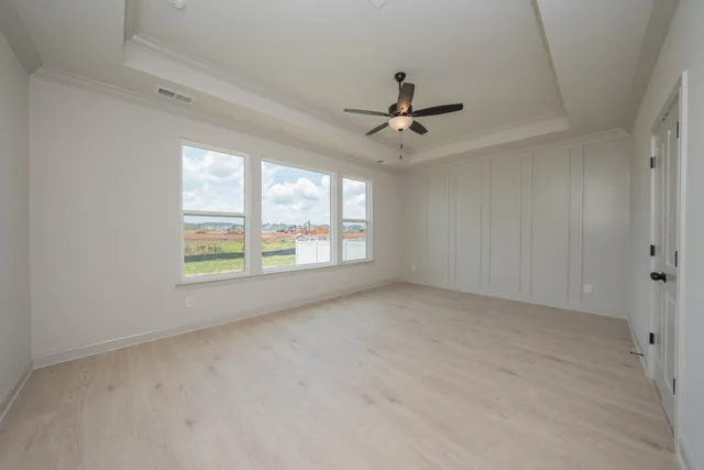 an empty room with a ceiling fan and a window