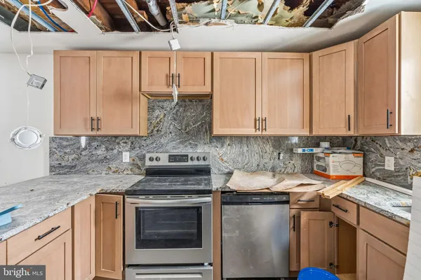 a kitchen with stainless steel appliances granite countertop white cabinets stove a sink and dishwasher