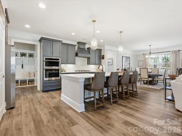 a large kitchen with white cabinets and stainless steel appliances