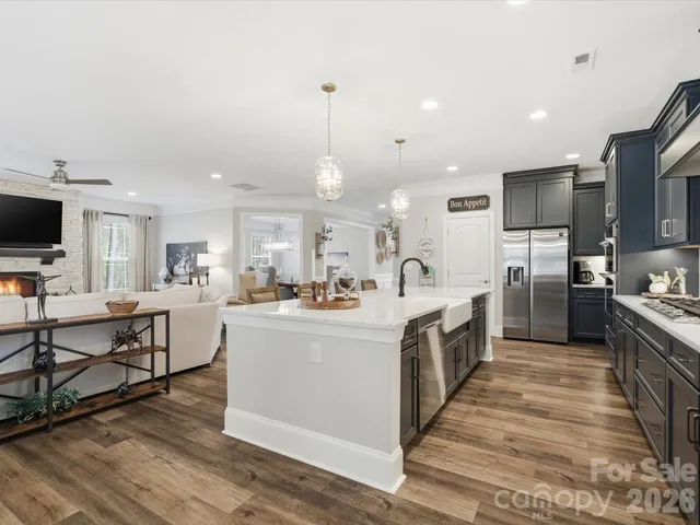 a large white kitchen with lots of counter space a sink and appliances