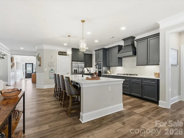 a large white kitchen with lots of counter space a sink and appliances