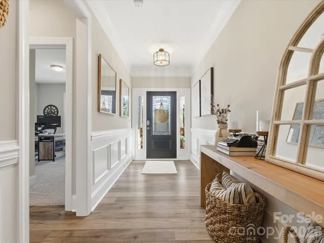 a view of a hallway with wooden floor and entryway