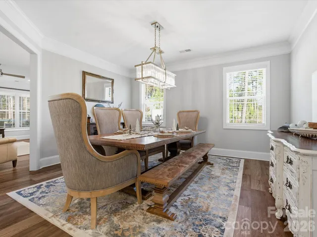 a dining room with furniture a chandelier and wooden floor